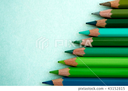 On the background of the abstract, colored pencils such as green, green, and blue are placed. On the background of the abstract, colored pencils such as green, green, and blue are placed. 43152815