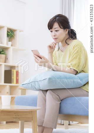 A woman operating a smartphone A woman operating a smartphone 43155823
