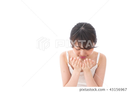 A young woman cleansing face A young woman cleansing face 43156967
