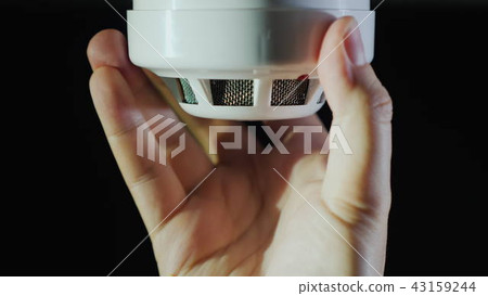 Man installs a sensor fire protection system Man installs a sensor fire protection system 43159244