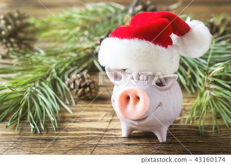 figure funny pig in Santa's hat on a wooden table figure funny pig in Santa's hat on a wooden table 43160174