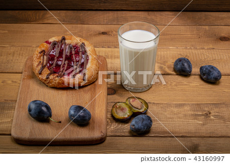 Breakfast.Cheesecake with jam and a glass of milk and a few sips 43160997