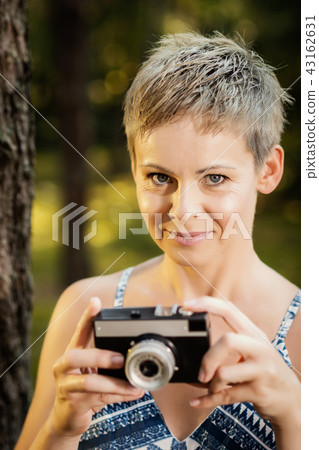 portrait of a beautiful woman with a camera in a summer forest 43162631