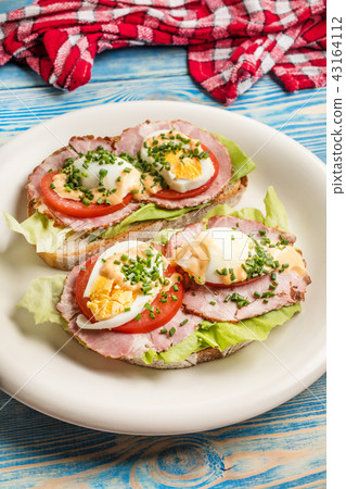 Sandwich with tomatoes, eggs and lettuce. 43164112