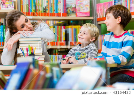 Mom being tired and exhausted from being with her kids in the library 43164423