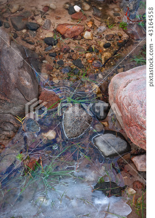 Stone in the ice on a sandy beach Stone in the ice on a sandy beach 43164558
