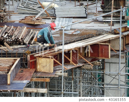 Construction workers fabricating timber form work. 43165355