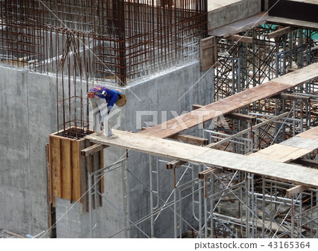 Construction workers fabricating timber form work. 43165364