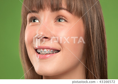 Beautiful young woman with teeth braces 43166572