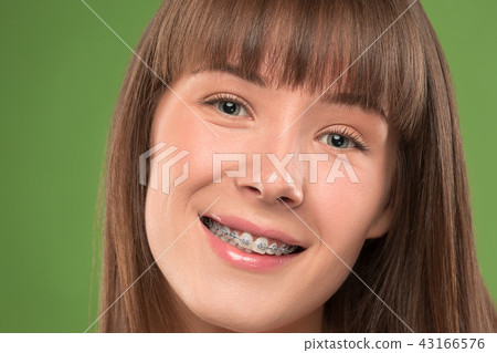 Beautiful young woman with teeth braces 43166576