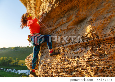 Pcture of curly-haired climber girl climbing rock Pcture of curly-haired climber girl climbing rock 43167483