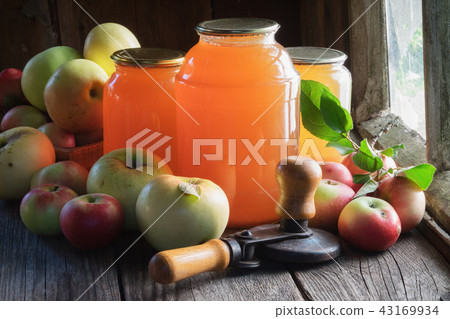 Jars of apple juice and can lid closing machine. 43169934