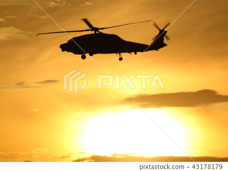 海上自衛隊的SH-60K海鷹反潛巡邏直升機在美麗的夕陽中飛行,染成琥珀色 海上自衛隊的SH-60K海鷹反潛巡邏直升機在美麗的夕陽中飛行,染成琥珀色 43178179