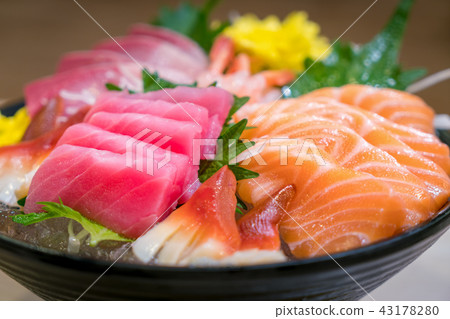 Mixed sliced fish sashimi on ice in black bowl. Mixed sliced fish sashimi on ice in black bowl. 43178280