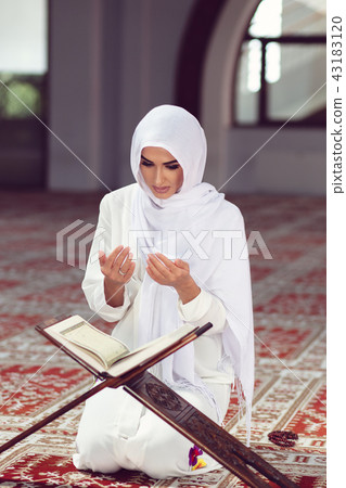 Young muslim woman praying in mosque with quran 43183120