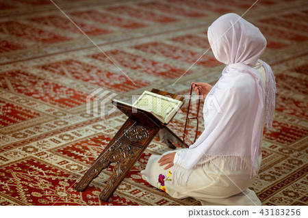 Young muslim woman praying in mosque with quran Young muslim woman praying in mosque with quran 43183256