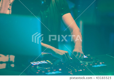 Dj mixes the track in the nightclub at party. DJ hands in motion 43183323
