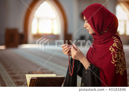 Young muslim woman praying in mosque with quran 43183896