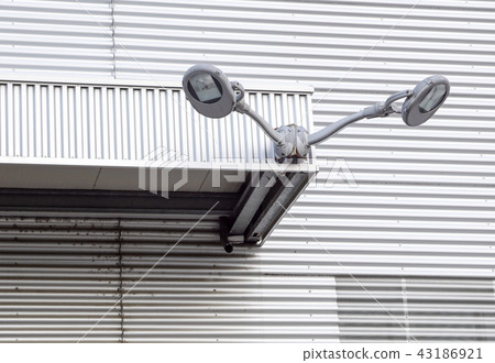 Street lamp near building that use aluminum panels for exterior decoration 43186921