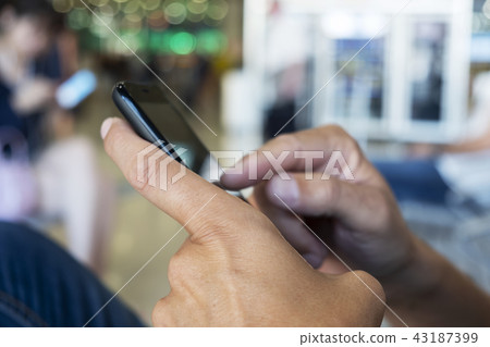 man using smartphone in a station or airport 43187399