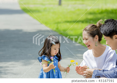 Three-person family playing in a fresh green park Three-person family playing in a fresh green park 43187591