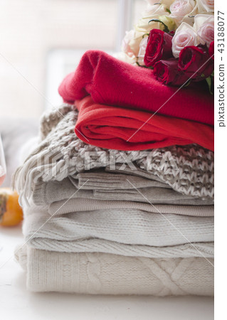 Different warm winter clothes at home near the window. Cozy photo. Different warm winter clothes at home near the window. Cozy photo. 43188077