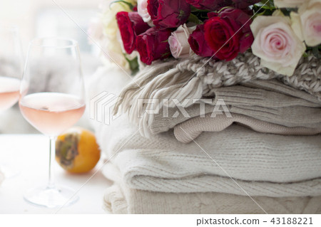Two glasses of wine and a lot of winter warm clothes at home near the window. Cat, large bouquet of Two glasses of wine and a lot of winter warm clothes at home near the window. Cat, large bouquet of 43188221