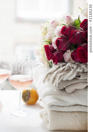 Two glasses of wine and a lot of winter warm clothes at home near the window. Cat, large bouquet of Two glasses of wine and a lot of winter warm clothes at home near the window. Cat, large bouquet of 43188236