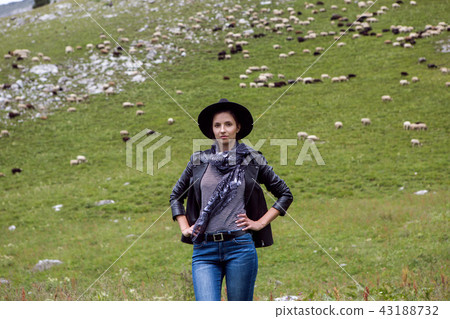 girl shepherd standing in the mountains in a meadow girl shepherd standing in the mountains in a meadow 43188732