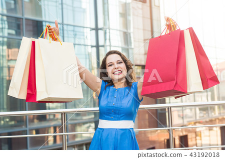 Purchase, sale and people concept - young happy smiling woman with shopping bags Purchase, sale and people concept - young happy smiling woman with shopping bags 43192018