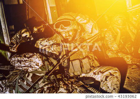Army team leader coordinating teammates with radio Army team leader coordinating teammates with radio 43193062
