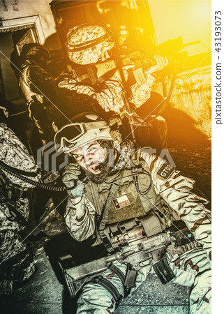 Army team leader coordinating teammates with radio Army team leader coordinating teammates with radio 43193073
