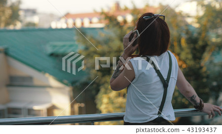 Young redhaired woman riding bicycle in city. Woman with mobile phone Young redhaired woman riding bicycle in city. Woman with mobile phone 43193437