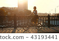 Red haired woman riding a bicycle on background sunlight in city 43193441