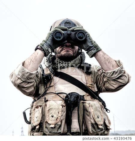 Commando soldier using binoculars to observe terrain 43193476
