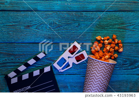 Clapperboard, glasses and popcorn on blue wooden background top view with copyspace 43193963