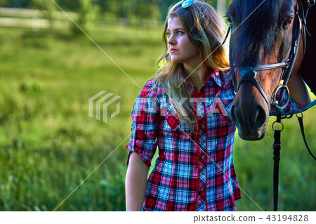 Beautiful girl with long hair on a walk with a horse. Summer evening. 43194828