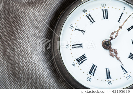 clock face of vintage pocket watch on gray textile clock face of vintage pocket watch on gray textile 43195659