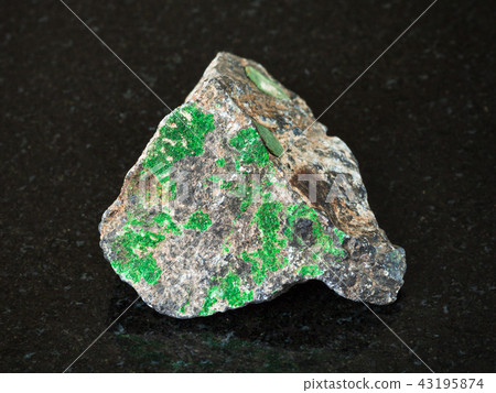 Uvarovite crystals on raw Chromite stone on black Uvarovite crystals on raw Chromite stone on black 43195874
