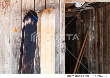 two pairs of wide forest skis near wooden shed 43196227