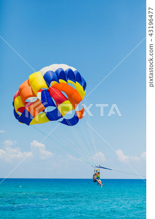 Couple of tourists flying on a colorful parachute 43196477