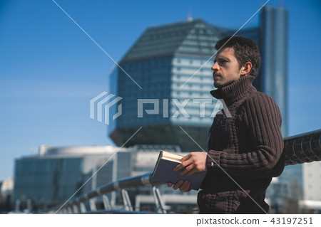 Young man studen reading book outdoors in sunny day 43197251