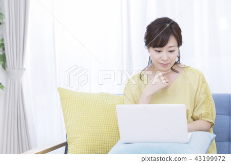 Woman operating a personal computer Woman operating a personal computer 43199972