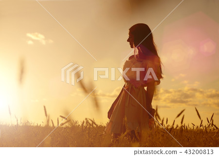 Woman in wheat field at sunset 43200813