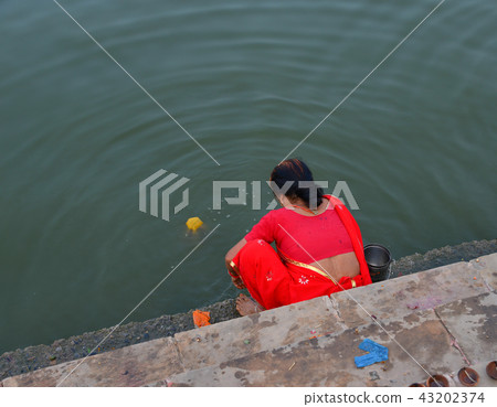 Indian people praying on riverbank 43202374