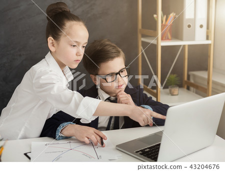 Little boy and girl working on laptop Little boy and girl working on laptop 43204676