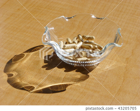 Herbal medicine capsule in a glass bowl 43205705
