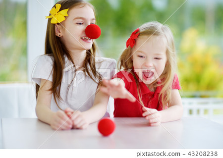 Happy little sisters wearing red clown noses 43208238