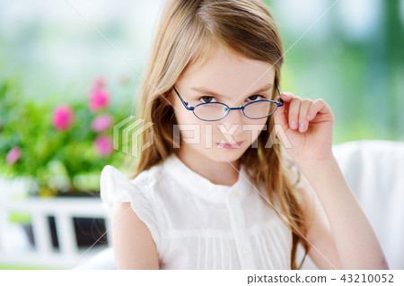 Portrait of cute little girl wearing glasses at home. Vision, health, ophthalmology concept. Portrait of cute little girl wearing glasses at home. Vision, health, ophthalmology concept. 43210052