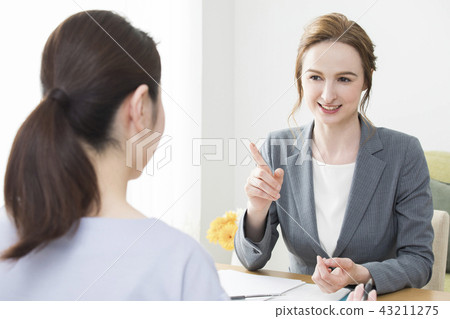 A Japanese woman talking to a foreign woman 43211275